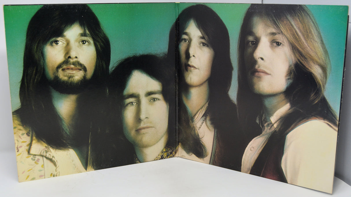 Album cover with four band members' faces on a green background
