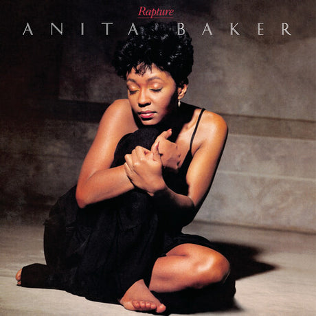 Baker, Anita - Rapture Album cover featuring a woman in a black dress sitting on steps with 'Anita Baker' and 'Rapture' text.