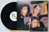 Vinyl record with a colorful cover featuring three women's faces.