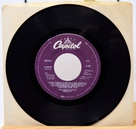 Vinyl record with a purple label featuring the Capitol Records logo on a wooden block.