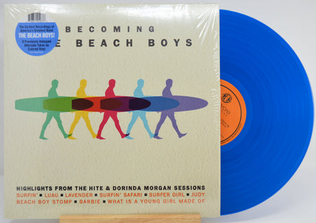 Becoming the Beach Boys vinyl record package on a white background, with the album cover in front and a blue record partially visible behind it. The cover shows the title 'BECOMING THE BEACH BOYS' and a row of colorful surfers carrying surfboards.