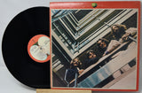 Vinyl record with cover featuring a group of people on a staircase