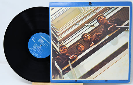 Vinyl record with a blue label and cover featuring people on a staircase.