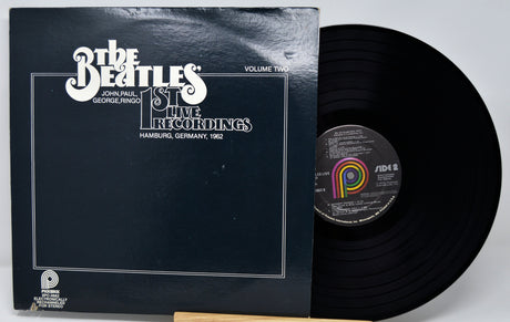Vinyl record and cover with 'The Beatles' logo on a white background