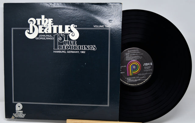 Vinyl record and cover with 'The Beatles' logo on a white background