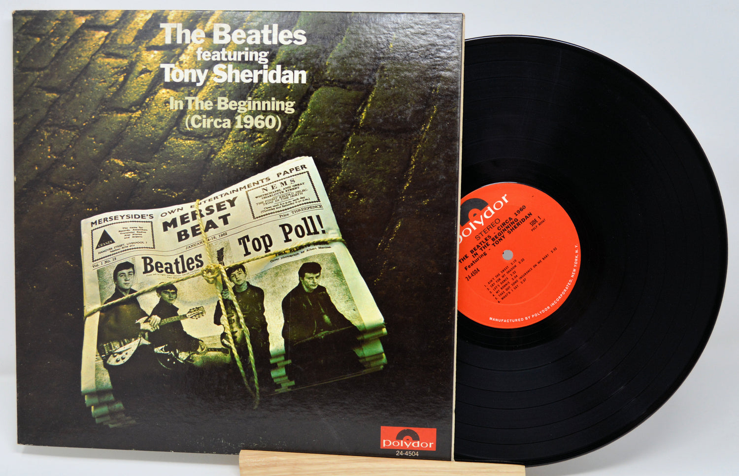 Vinyl record with cover featuring The Beatles and Tony Sheridan, on a light gray background.