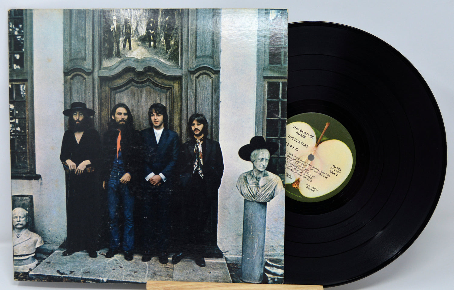 Vinyl record with cover featuring a group of people and an apple logo.