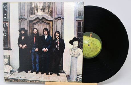 Vinyl record with a cover featuring a group of people and an apple logo.
