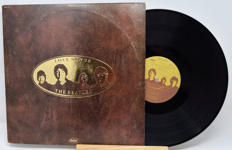 Vinyl record and cover with 'The Beatles' artwork on a white background