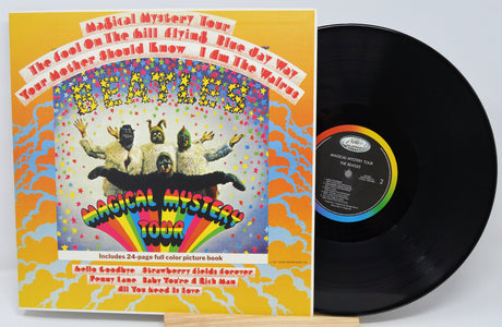 Vinyl record and cover of The Beatles' 'Magical Mystery Tour' album on a white background