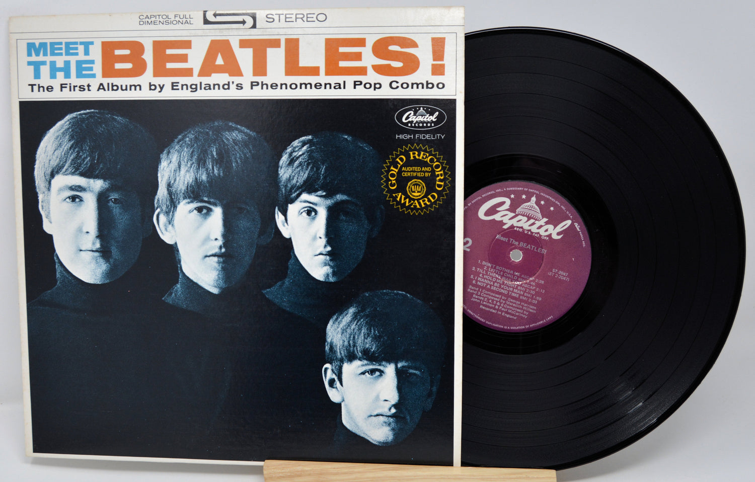Vinyl record with 'Meet the Beatles!' album cover featuring four band members.