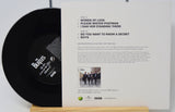 Vinyl record with cover featuring The Beatles text and image