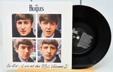 Vinyl record and cover with The Beatles' face on a white background
