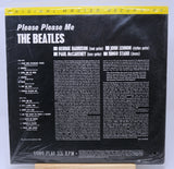 Vinyl record cover for 'Please Please Me' by The Beatles with yellow text and a photo of the band members.
