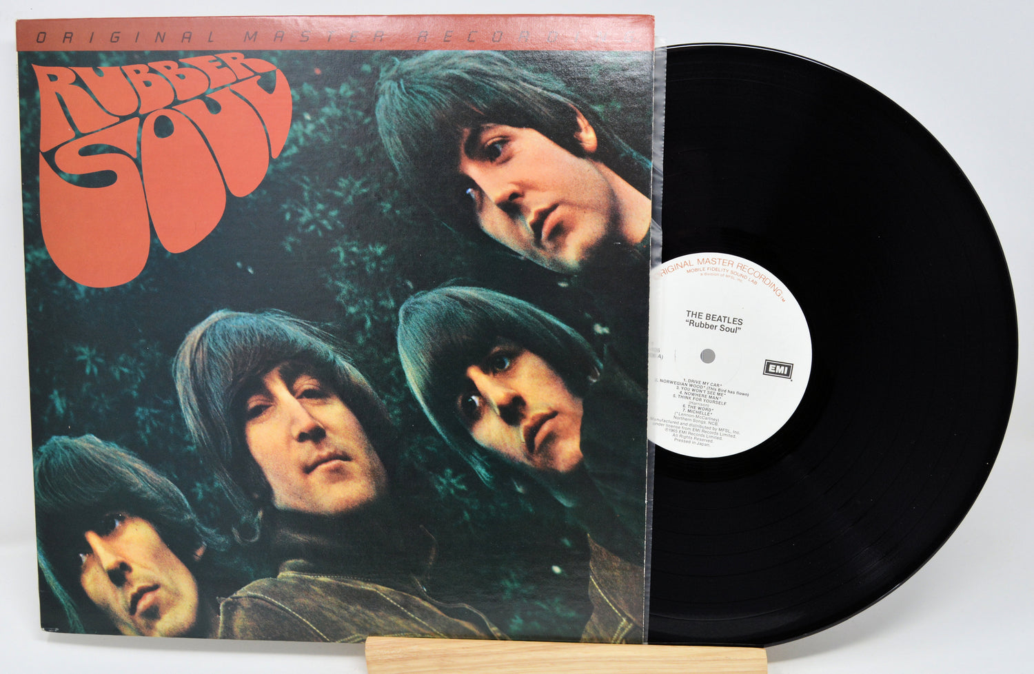 Vinyl record and cover of 'Rubber Soul' by The Beatles on a white background