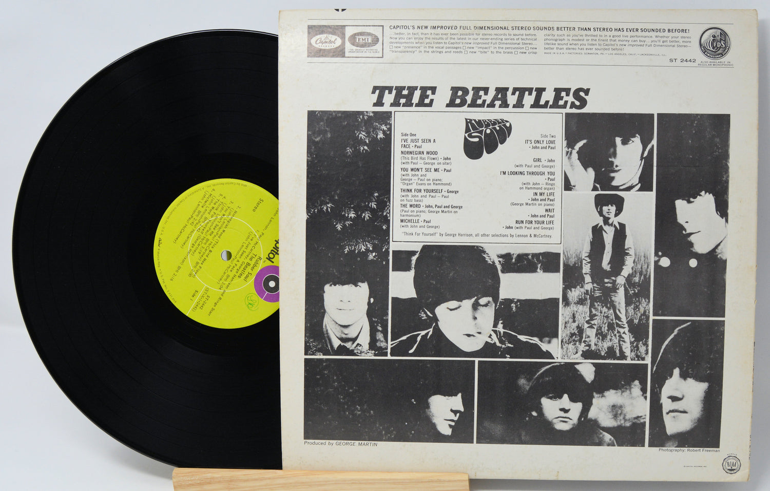 Vinyl record with cover featuring The Beatles' album art on a light gray background
