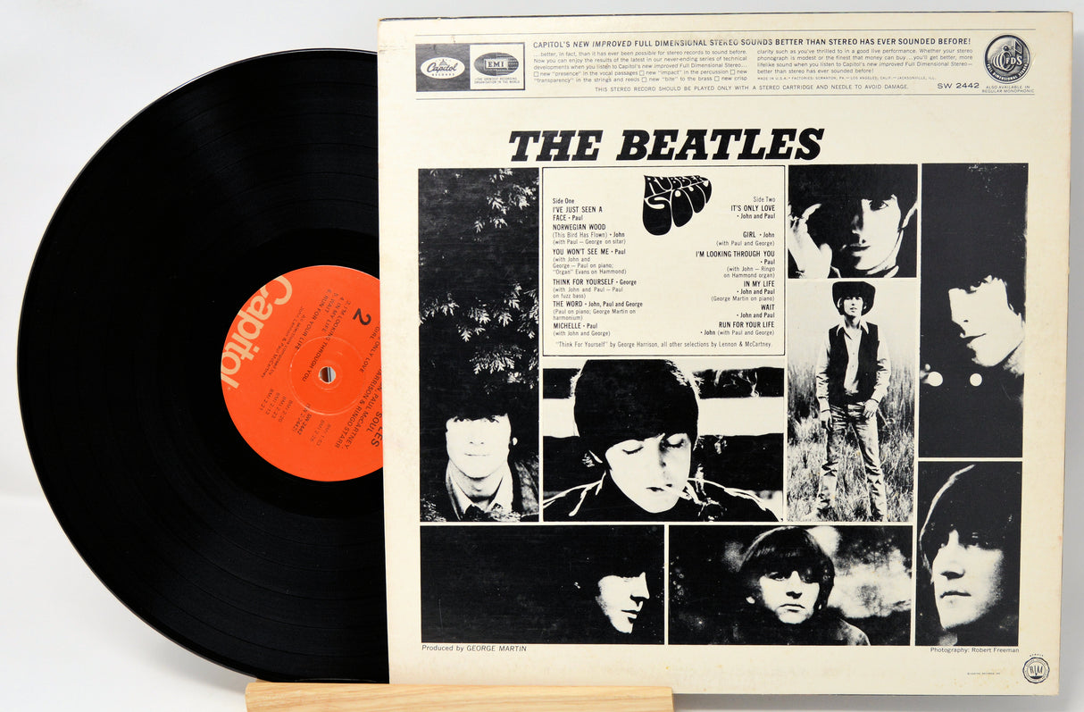 Vinyl record with its cover featuring The Beatles' album art on a white background