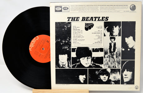 Vinyl record with its cover featuring The Beatles' album art on a white background