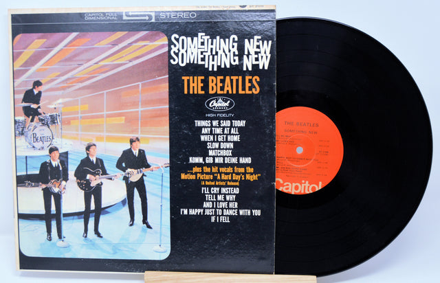 Vinyl record and cover of 'Something New' by The Beatles on a light blue background