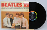 Vinyl record with cover featuring The Beatles on a light gray background