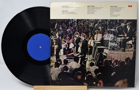 Vinyl record with a blue label and cover featuring a band performance.