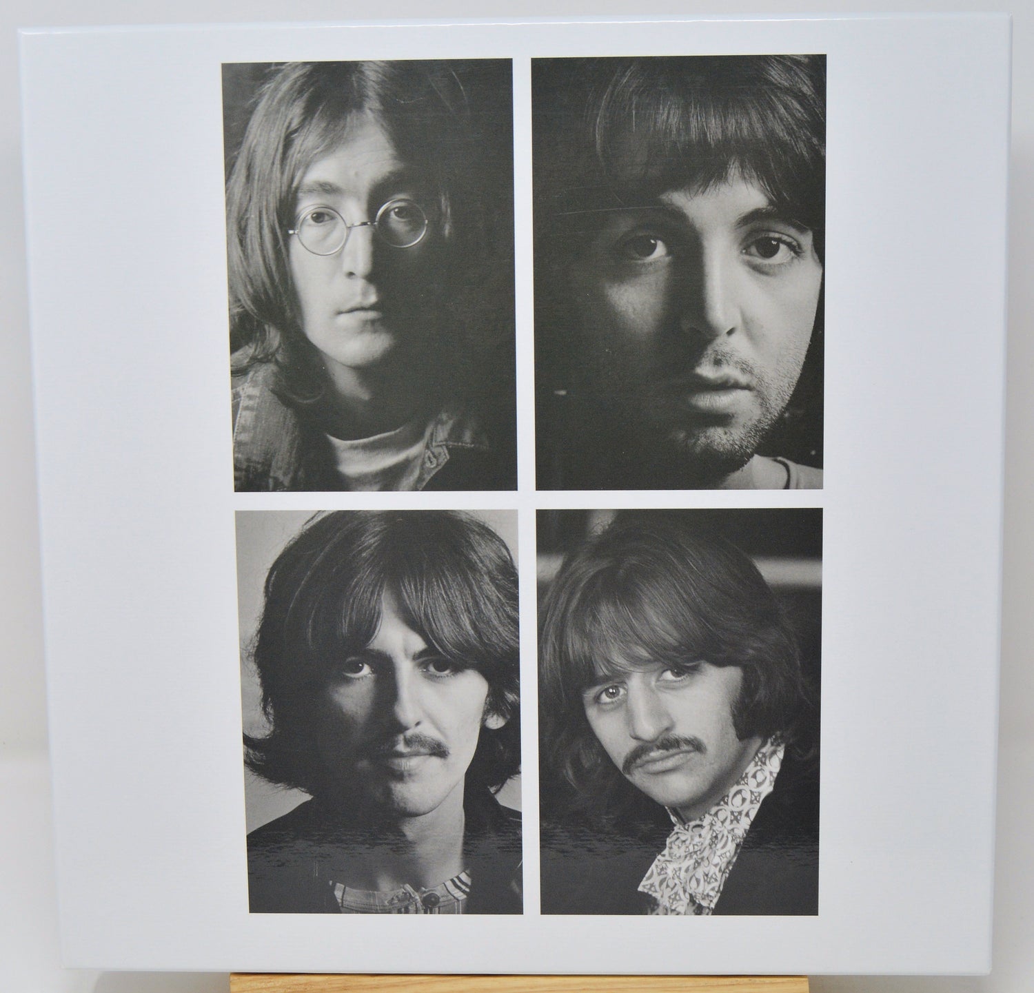 Black and white portraits of four individuals arranged in a 2x2 grid on a light background.