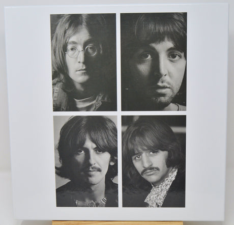 Black and white portraits of four individuals arranged in a 2x2 grid on a light background.