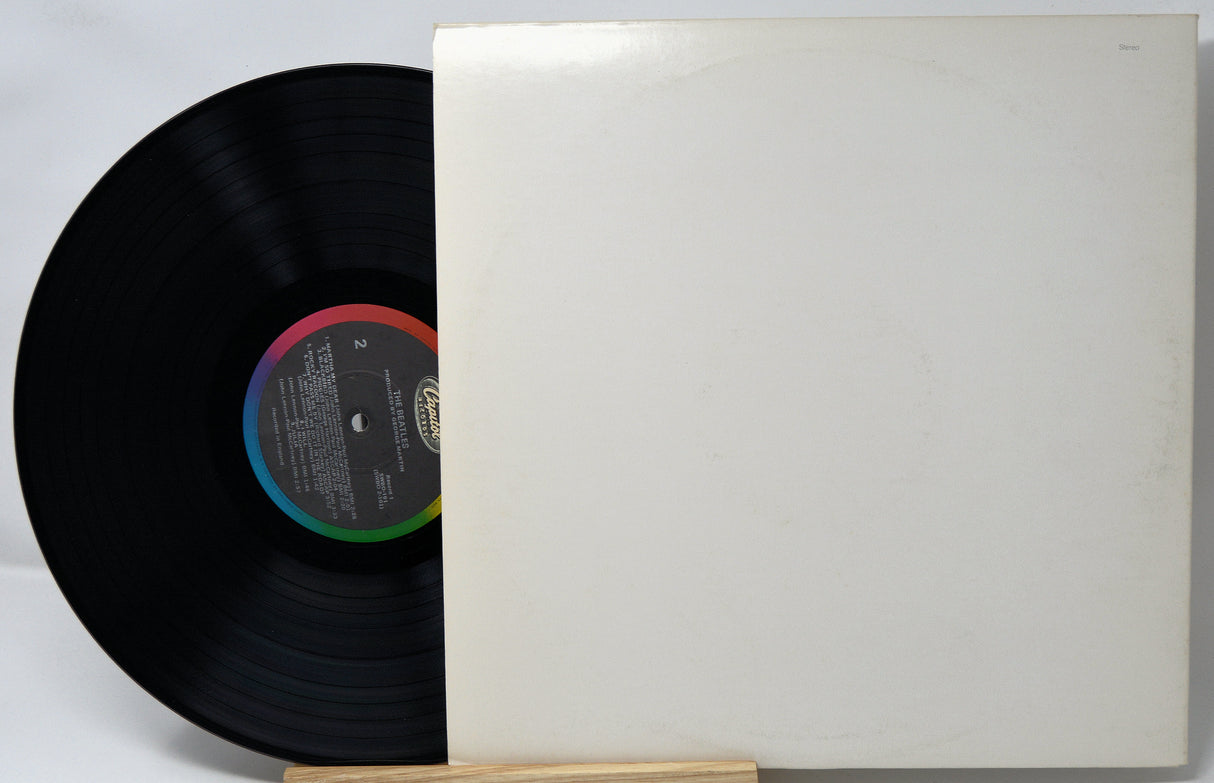 Vinyl record with a white cover on a light gray background