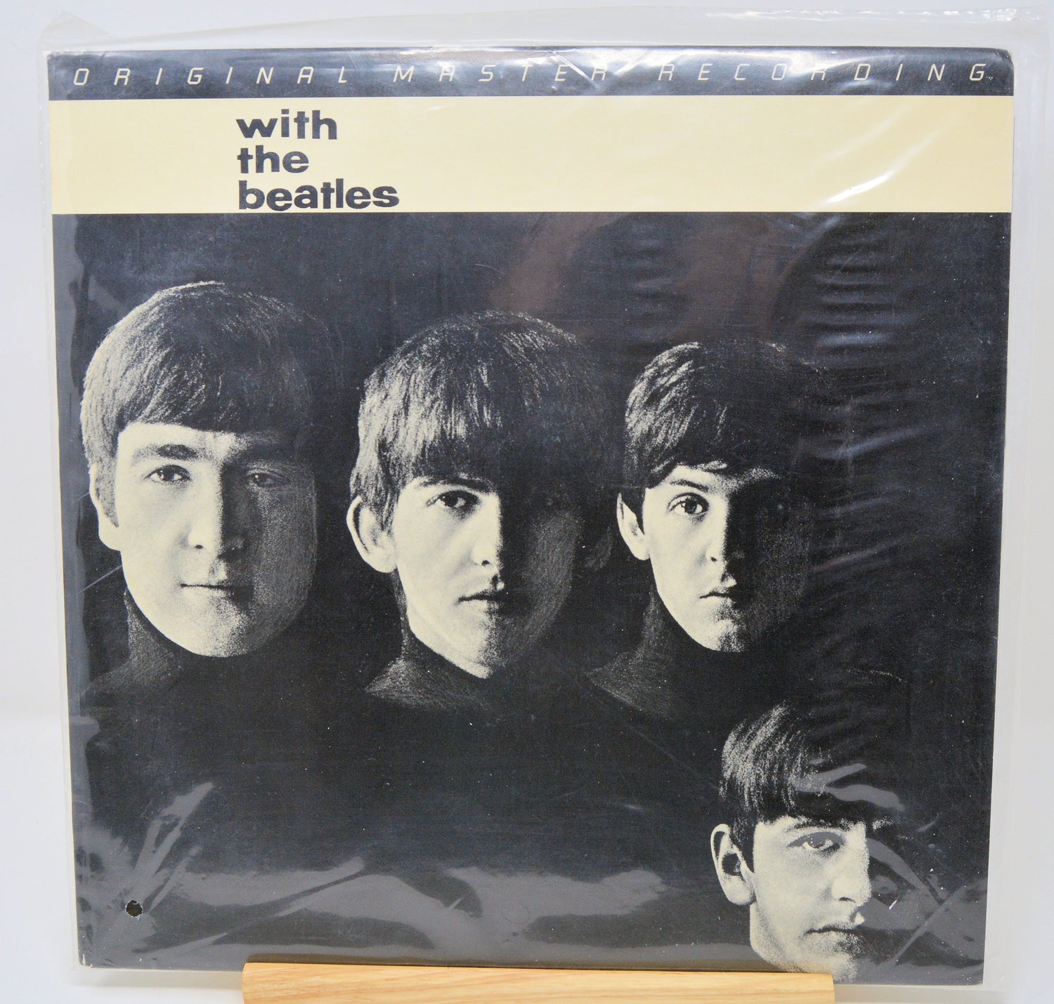 Vinyl record cover with black and white photo of four individuals and text 'with the beatles' on a beige background.