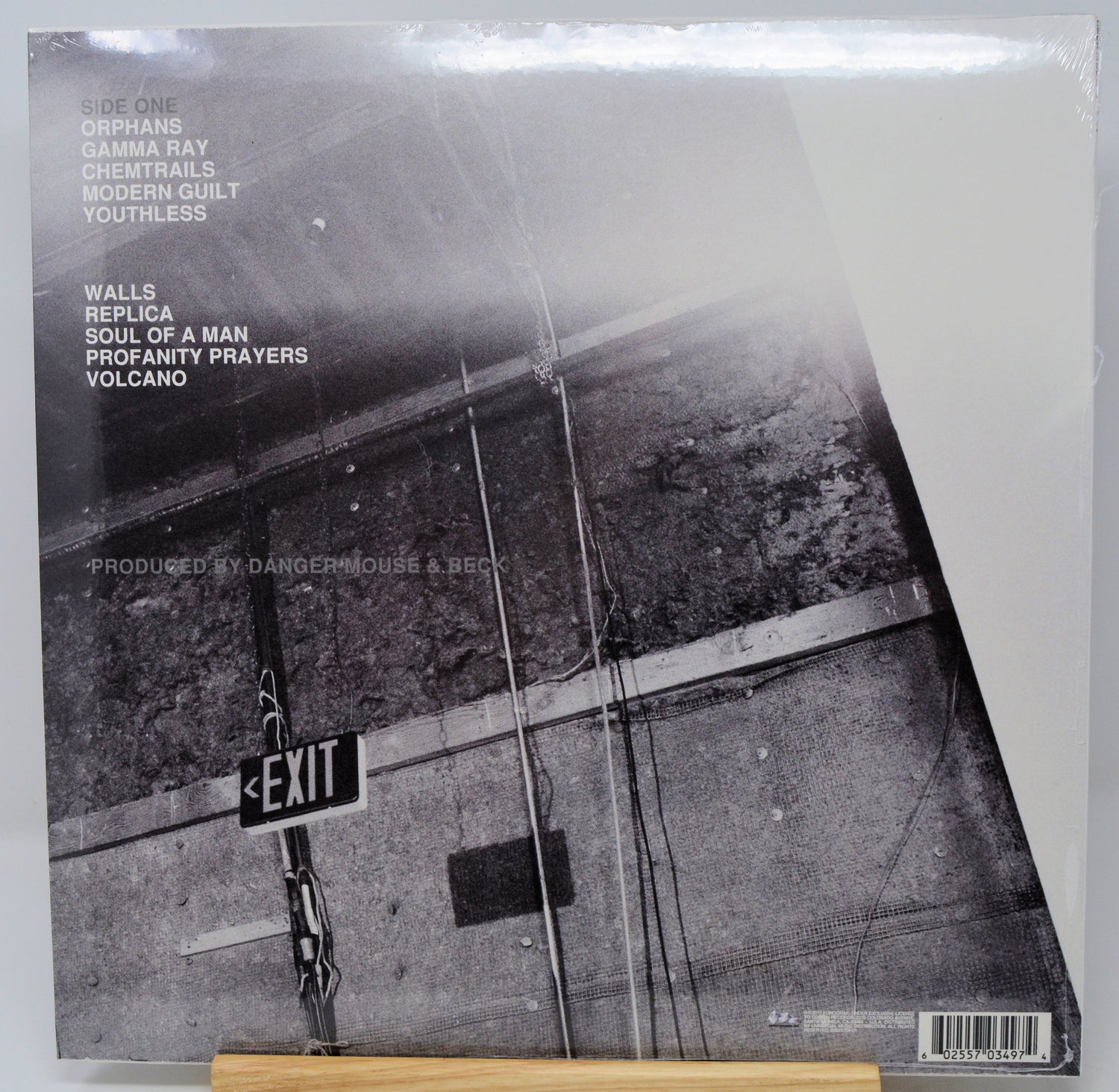 A vinyl record sleeve for the band Drowning Pool, featuring a black and white street scene with an EXIT sign. The tracklist is printed on the left side, and the record is sealed in shrink wrap, resting on a wooden surface.