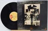 Vinyl record with cover featuring a black and white photo of musicians and album details.