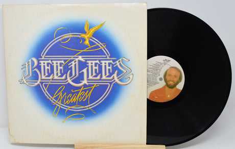 Vinyl record with cover featuring Bee Gees logo and a portrait of a man on a white background