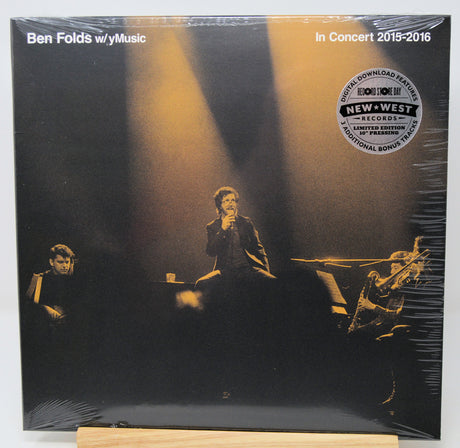 Ben Folds w/ y'music 'In Concert 2015-2016' vinyl record album, sealed in plastic shrink wrap, displayed on a wooden stand against a white background.