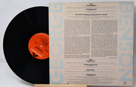 Vinyl record with black disc and detailed cover on a white background