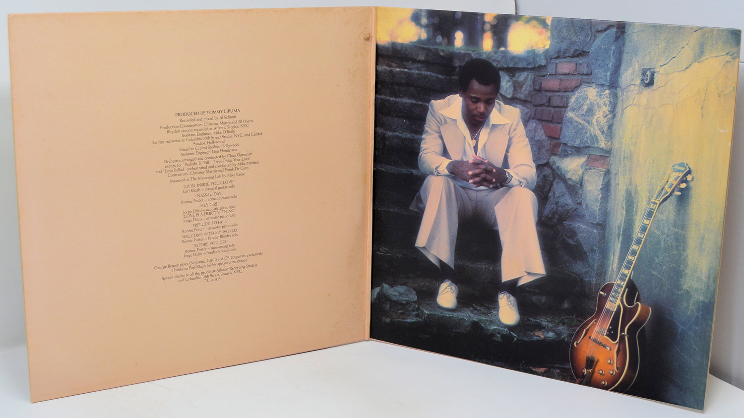 Album cover with a person sitting on steps next to a guitar