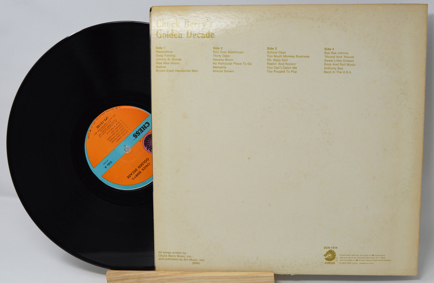 Vinyl record with orange label and beige record cover on a white background
