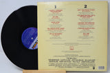 Vinyl record with its cover displaying track listings on a white background