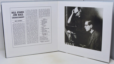 An open book or magazine spread showing a printed article on the left page with the headline 'Bill Evans Jim Hall Undercurrent' and a black-and-white photograph on the right page depicting two men seated at a piano.