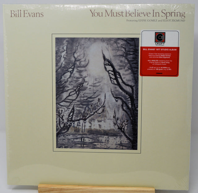 Bill Evans 'You Must Believe In Spring' LP album cover on a light cream background, featuring a black-and-white sketch of bare trees and a red CMT sticker on the right.
