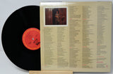 Vinyl record with cover featuring a list of songs and a photo of a person.