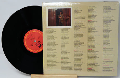 Vinyl record with cover featuring a list of songs and a photo of a person.