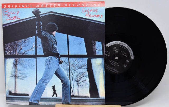 Billy Joel's 'Glass Houses' original master recording vinyl LP, showing the illustrated album cover on the left and the black vinyl record partially pulled out on the right.
