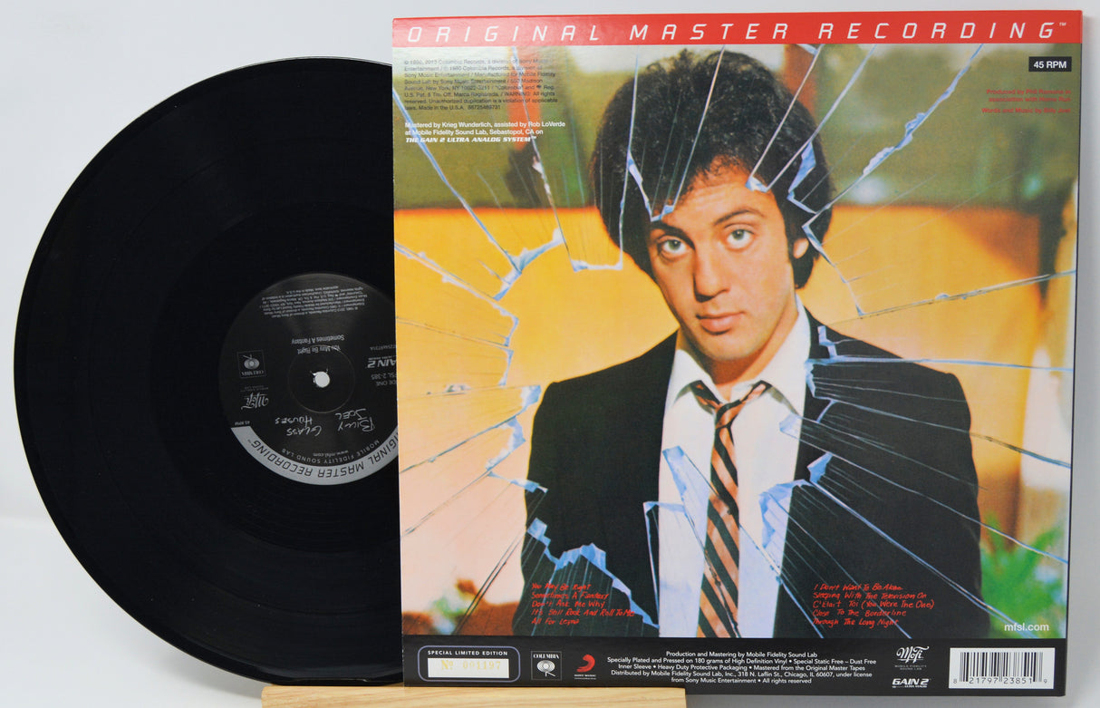 A vinyl record partially pulled from its album cover, showing the black disc on the left and the printed cover art on the right. The cover features a portrait of a man in a suit with a cracked-glass graphic overlay and the text 'ORIGINAL MASTER RECORDING' at the top.