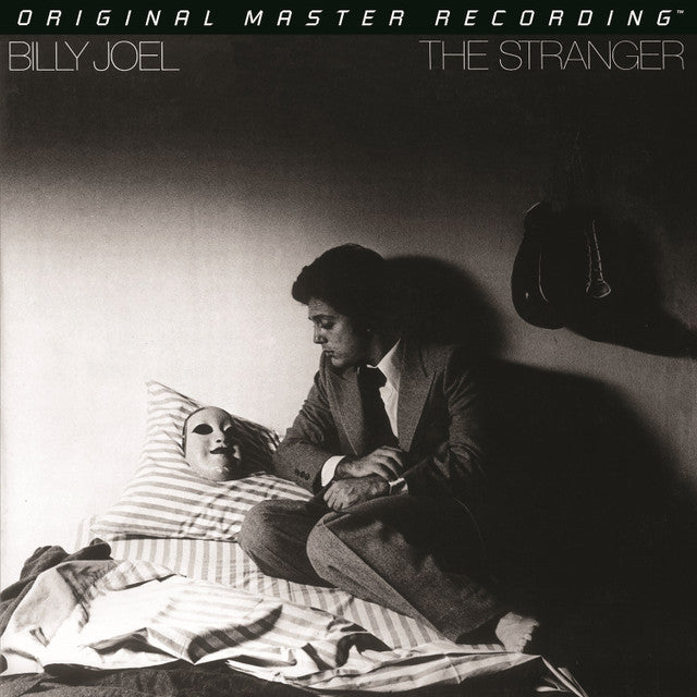 Album cover for 'The Stranger' by Billy Joel featuring a black and white photo of a man and woman in bed.