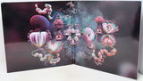 A square art print or poster displayed open against a white surface, featuring surreal abstract organic forms in pink, purple, teal, and cream on a dark background.