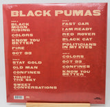 Black Pumas 'Colors' vinyl record album cover back, shown shrink-wrapped on a wooden display stand against a white background.