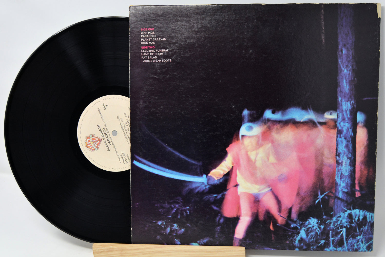 Vinyl record with a colorful album cover featuring a person and abstract elements.