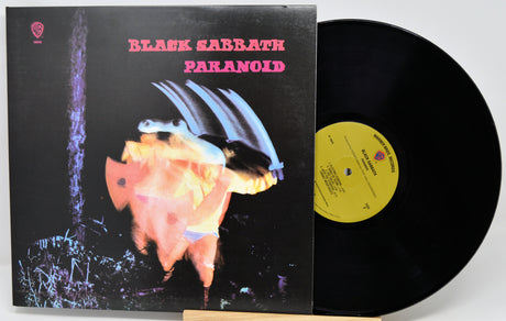 Black Sabbath - Paranoid vinyl record album with the LP partially pulled from the jacket, showing the black record, yellow center label, and album cover artwork.