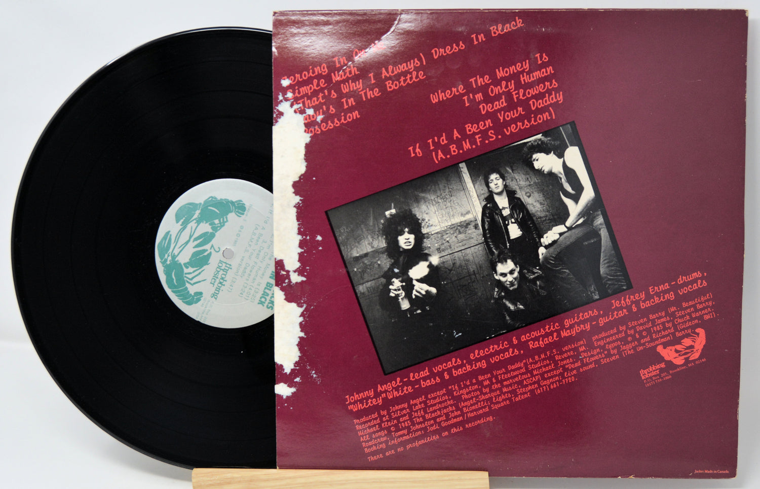Vinyl record with a red cover featuring a black and white photo and text.