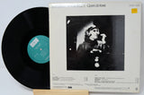 Vinyl record and its cover with a black and white image of a person on a light gray background